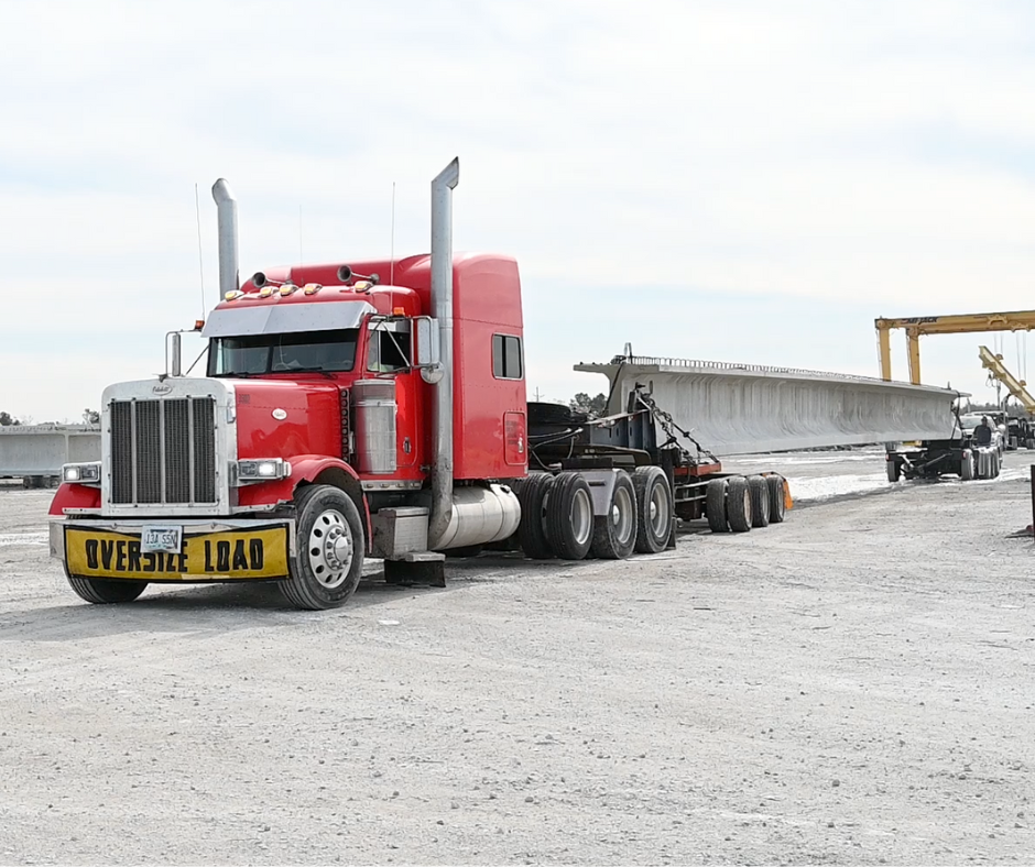 A bridge beam is being moved from the manufacturing site in Lake Charles, Louisiana to the construction site on the highway