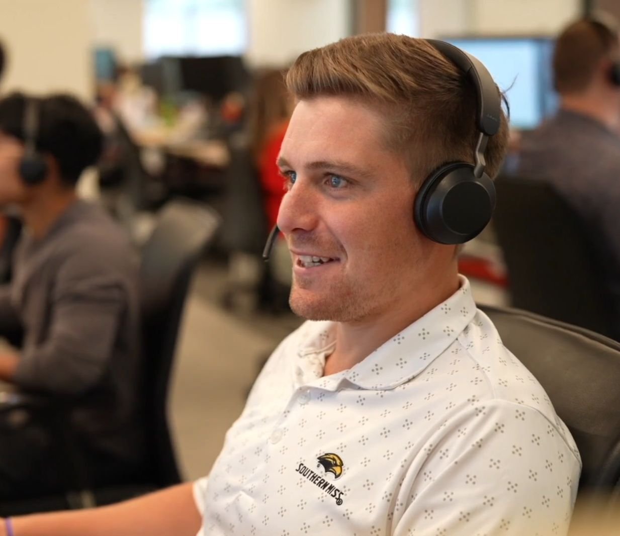 Zac Irby, an Inside Sales Representative at Jones Logistics, is pictured smiling with a headset on.